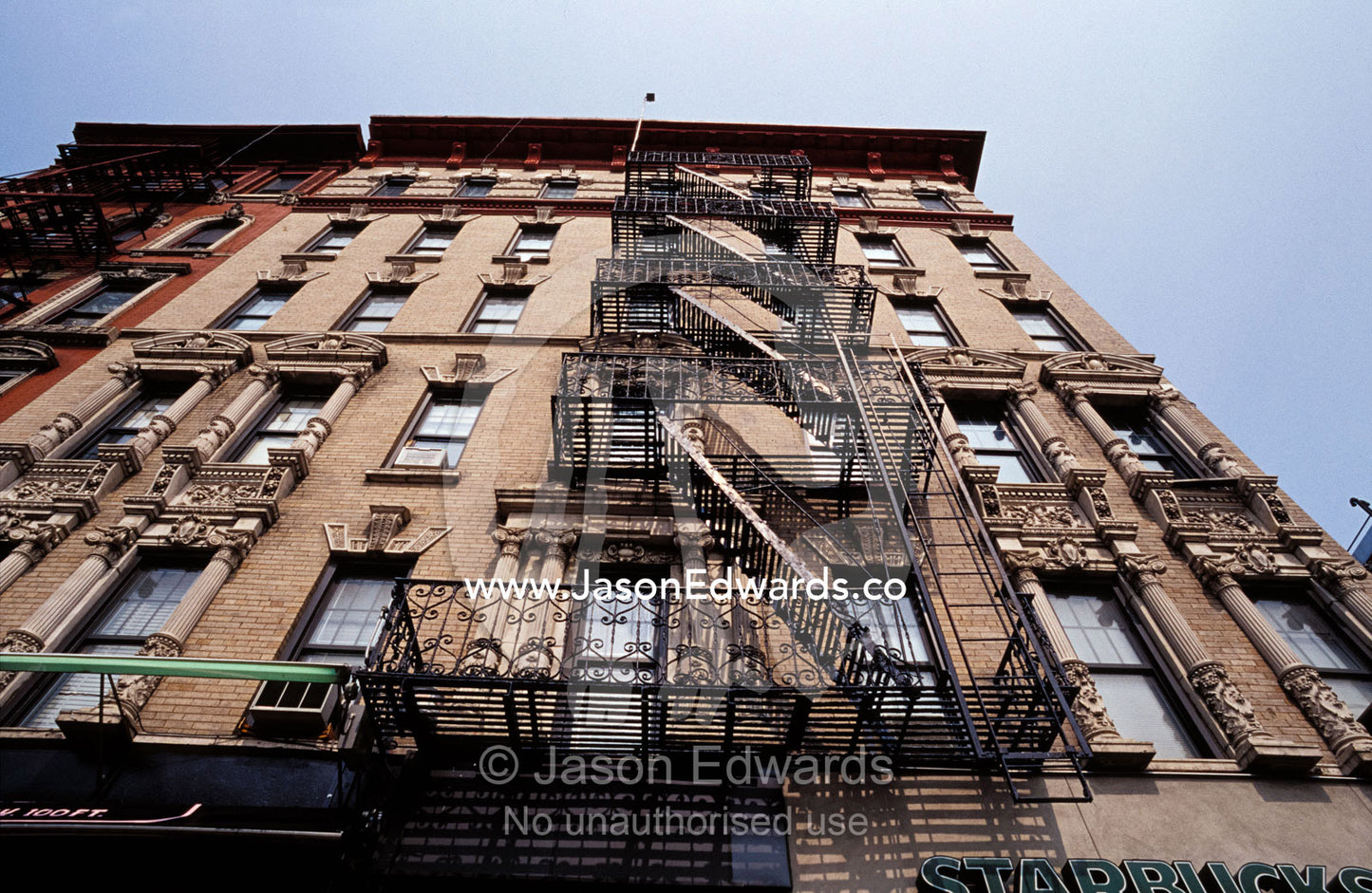Looking up at an East Village apartment building with fire escapes. New York City, United States of America.