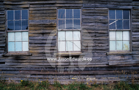 Three panelled windows on a dilapidated antique timber shed. Linton, Victoria, Australia.