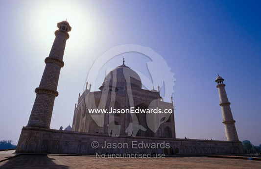 The Taj Mahal and two minarets silhouetted against a clear blue sky. Agra, India.