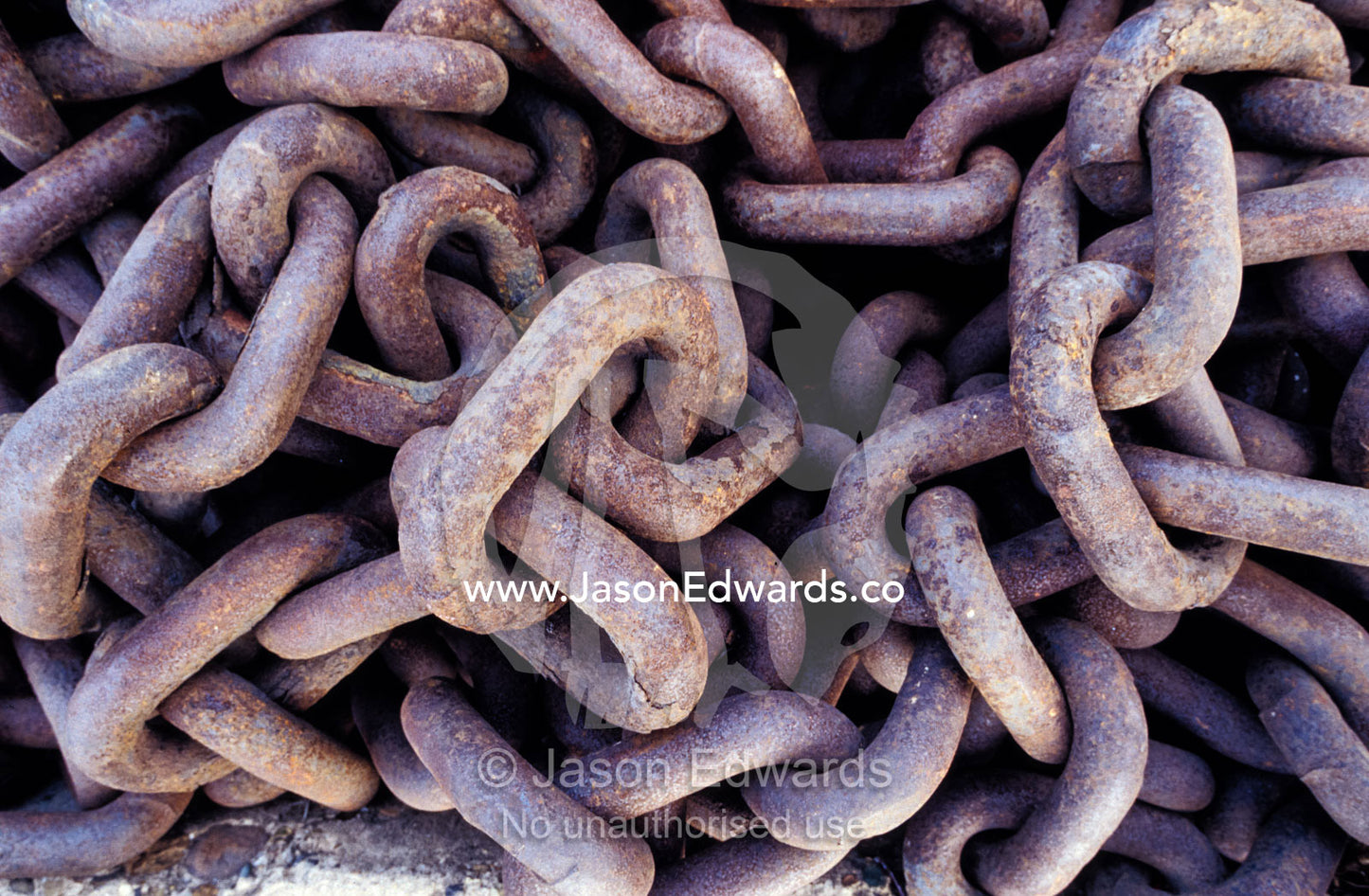 Rust oxidisation on discarded ship chains resting on a dock. Woollongong, New South Wales, Australia.
