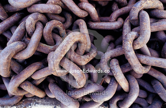 Rust oxidisation on discarded ship chains resting on a dock. Woollongong, New South Wales, Australia.