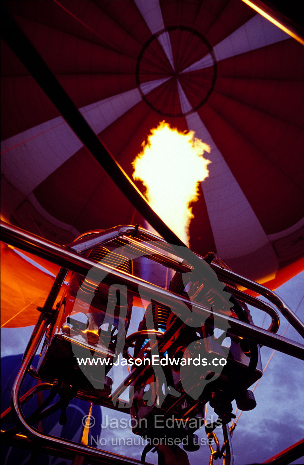 The red canopy of a Hot Air Balloon taking-off, with gas jet flame. Yarra Valley, Victoria, Australia.