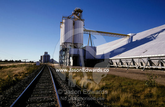 Railway line tracks leading to a wheat depot with silos. Moree, New South Wales, Australia.
