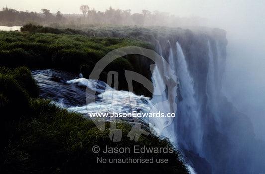 The Iguazu River cascades over the precipace into the misty abyss. Rio Iguazu, Argentina Brazil border