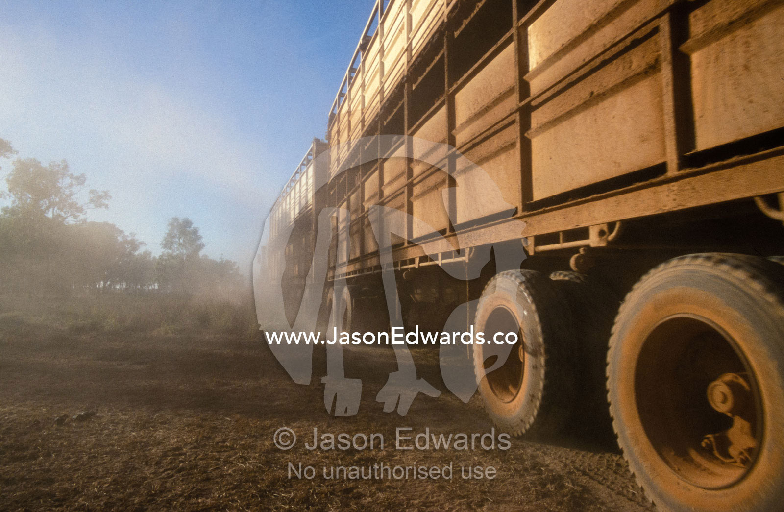 The wheels of a longhall road train churn up the dust in the outback. Epping Forest Station, Queensland, Australia.
