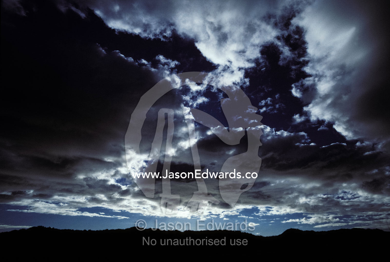 Ominous storm clouds roll in over a coastal desert escarpment. Cape Range National Park, Western Australia.