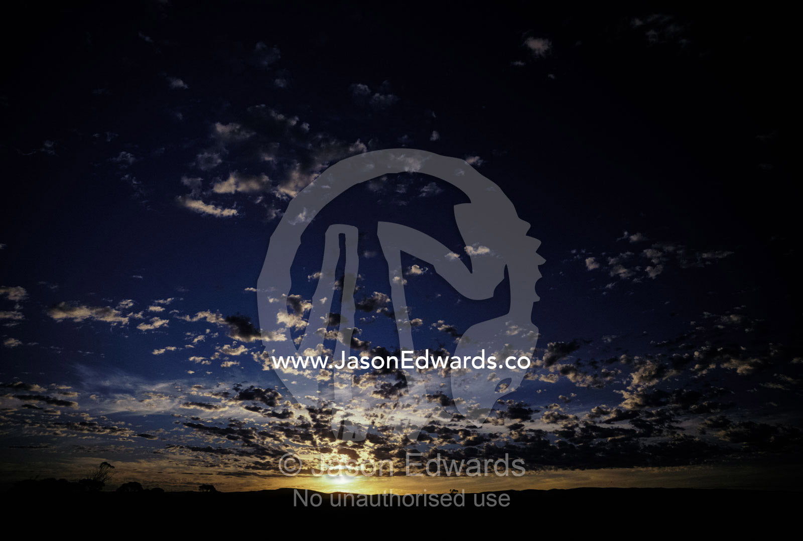 Dawn pierces scattered clouds over a coastal plain. Eyre Penninsula, South Australia.