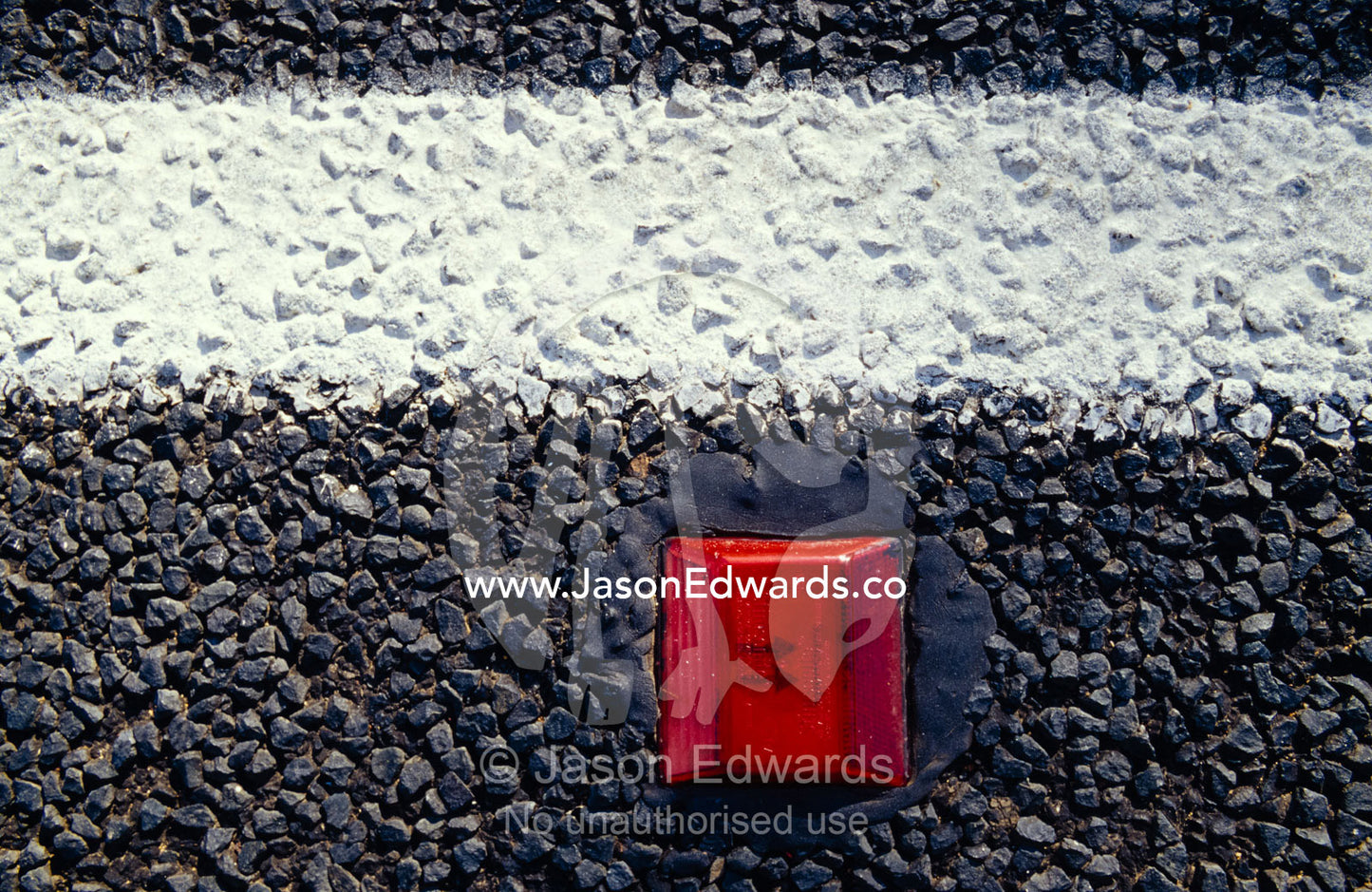 A white line and red reflective marker set into the road bitumen. Coonabarrabran, New South Wales, Australia.
