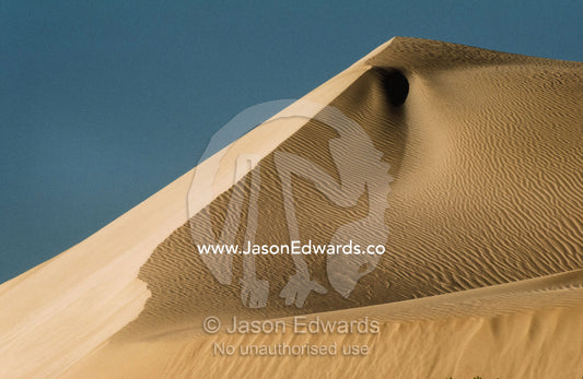 A vast sand dune ridge and peak with wind blown patterns and hollows. Nullarbor National Park, South Australia.