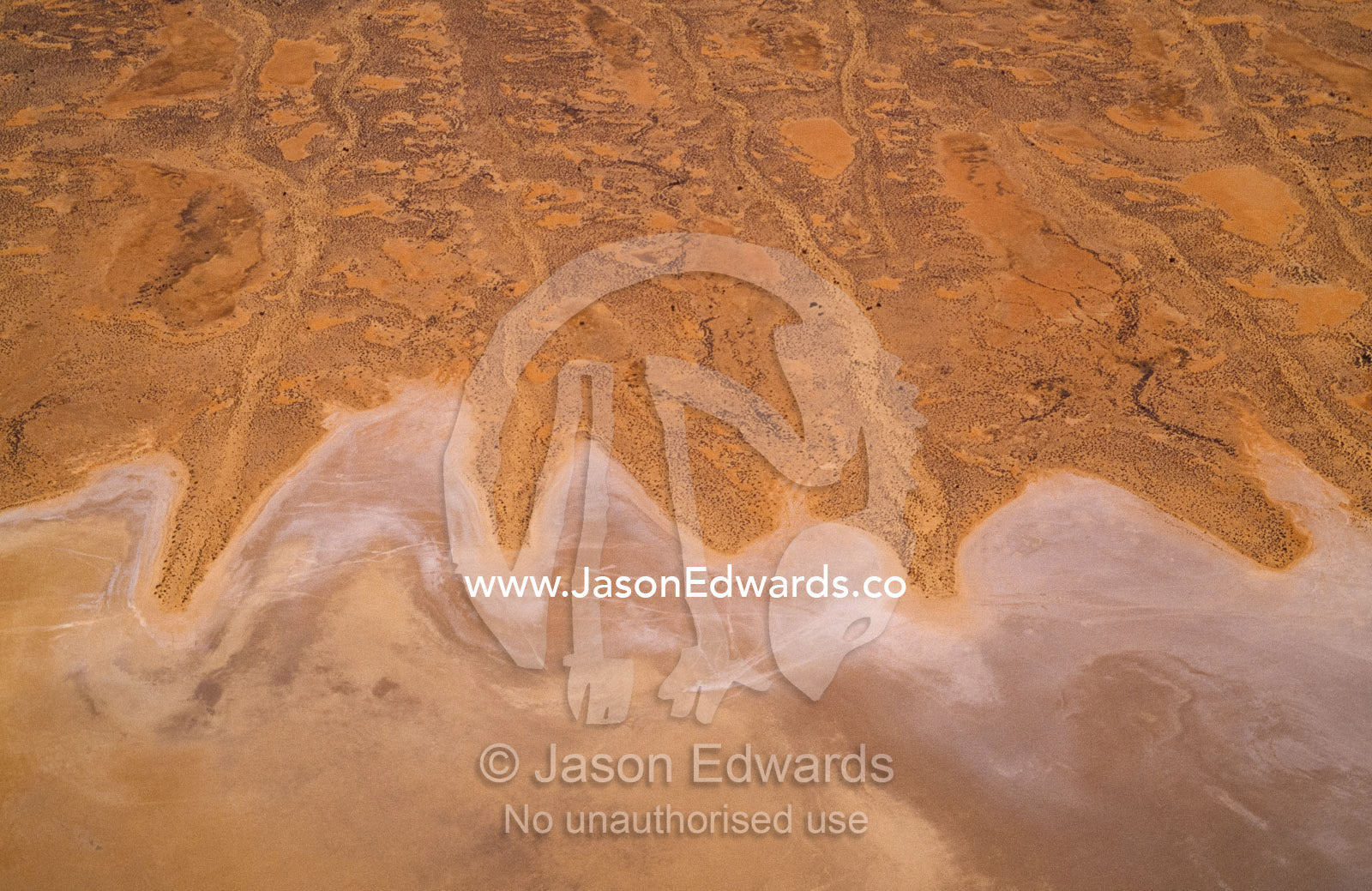 Aerial view of salt dunes and shoreline of vast Lake Eyre. Lake Eyre National Park, South Australia.