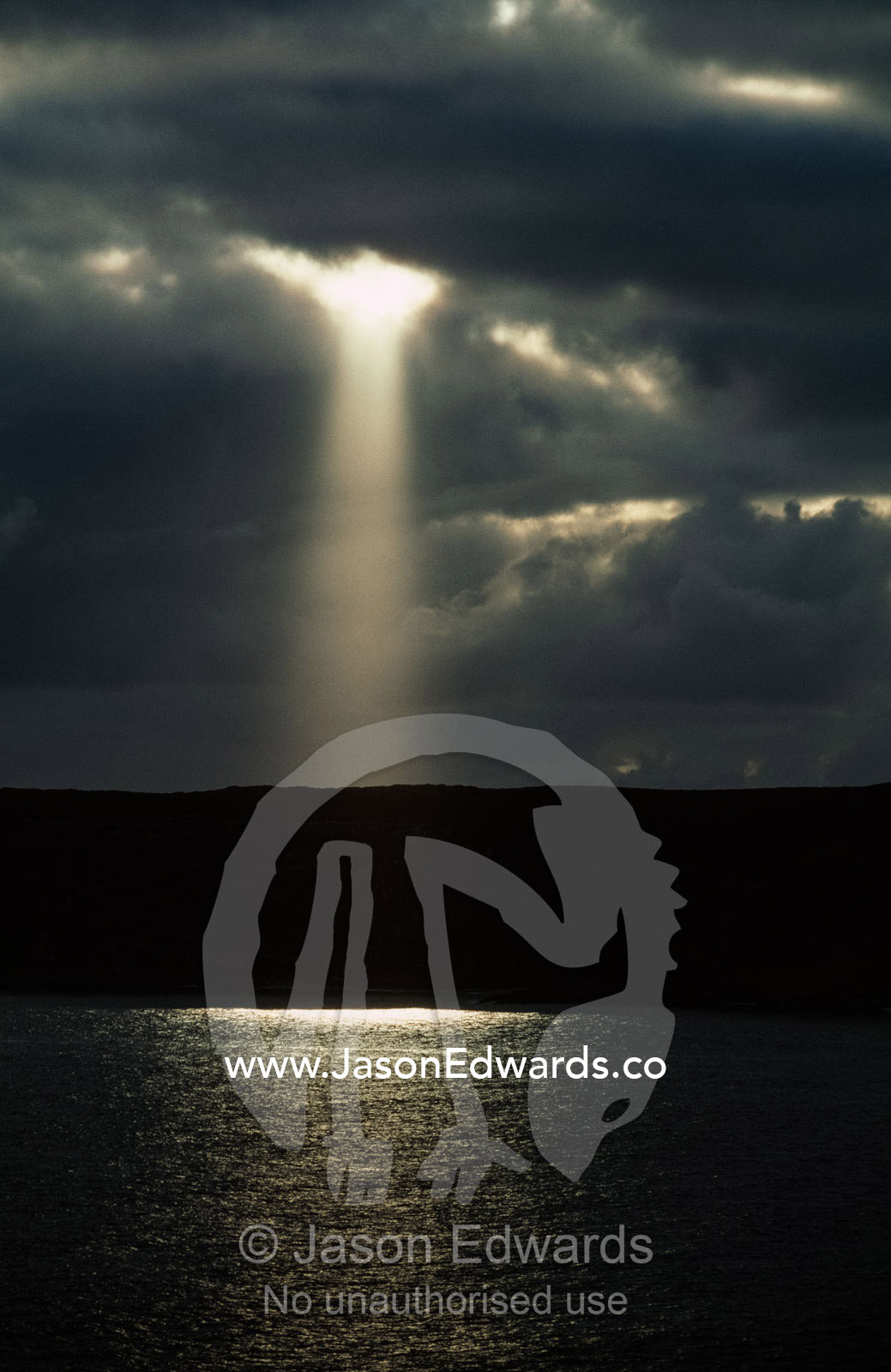 Sun rays breaking through storm clouds to illuminate the ocean. Kangaroo Island, Cape du Couedic, South Australia.