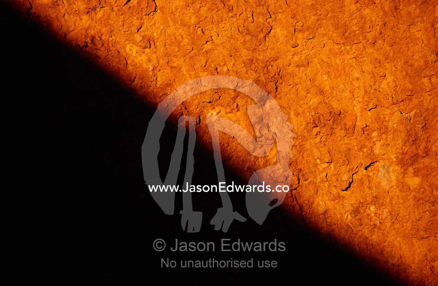 Close up of rust and oxidation and a cast shadow on Uluru sandstone. Uluru/Kata Tjuta National Park, Northern Territory, Australia.
