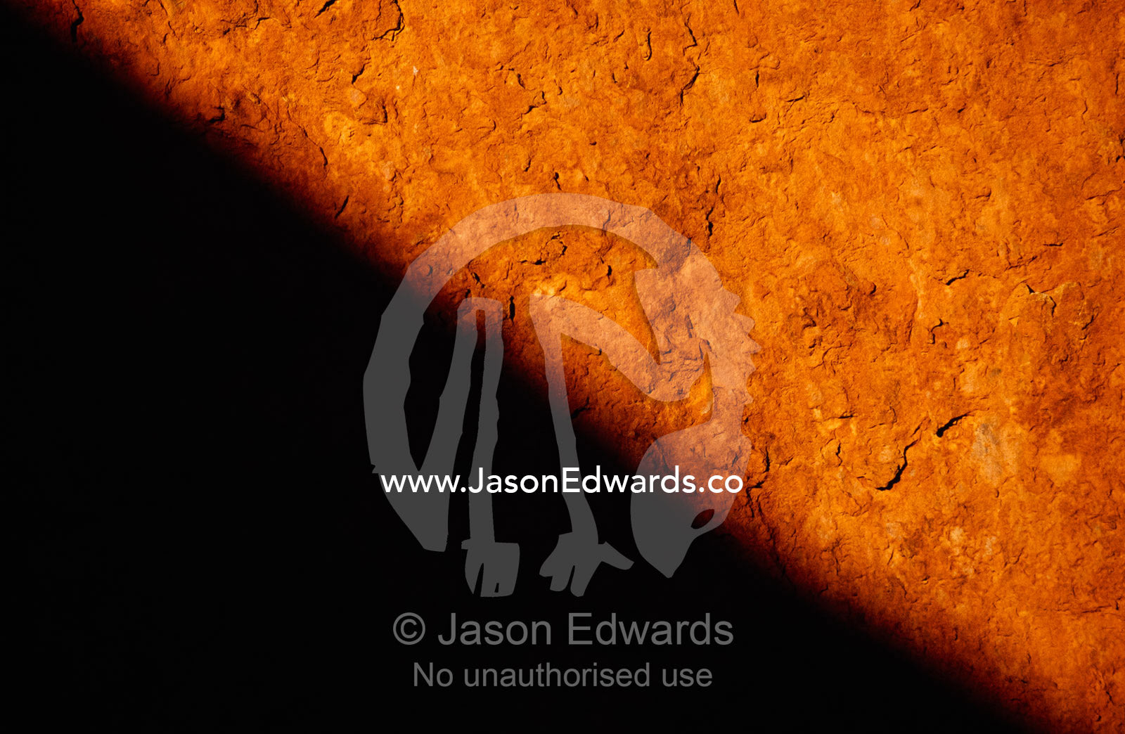 Close up of rust and oxidation and a cast shadow on Uluru sandstone. Uluru/Kata Tjuta National Park, Northern Territory, Australia.