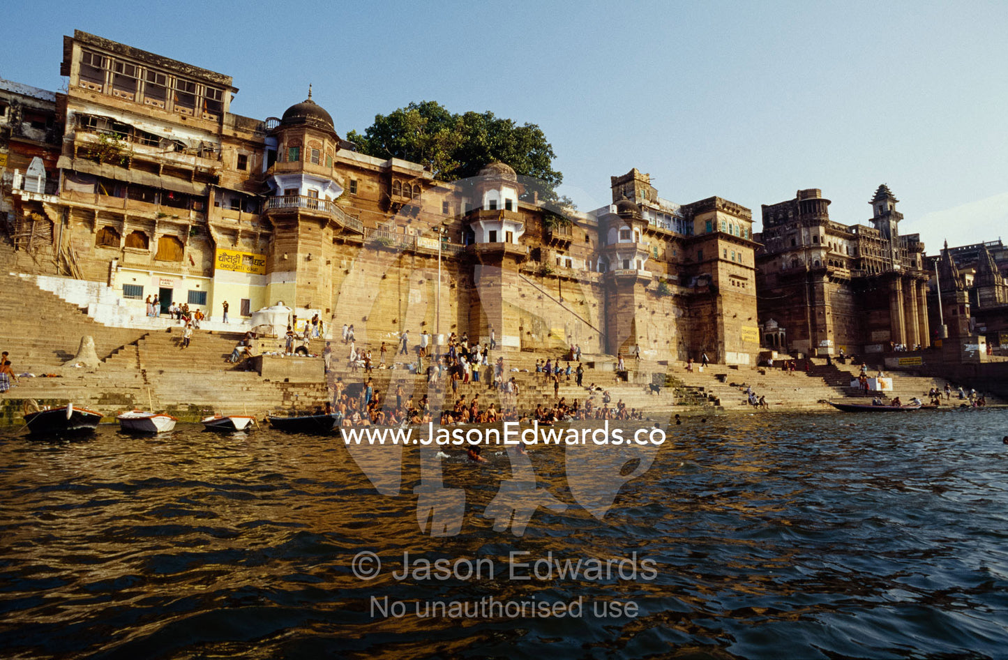 Crowds bathing and on the steps leading into the Ganges River. Varanasi (Benares), India.
