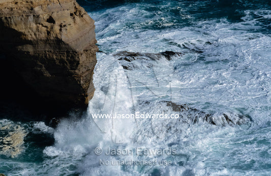 Waves smash against the surface of The Arch sandstone formation. Cape Otway National Park, Victoria Australia.