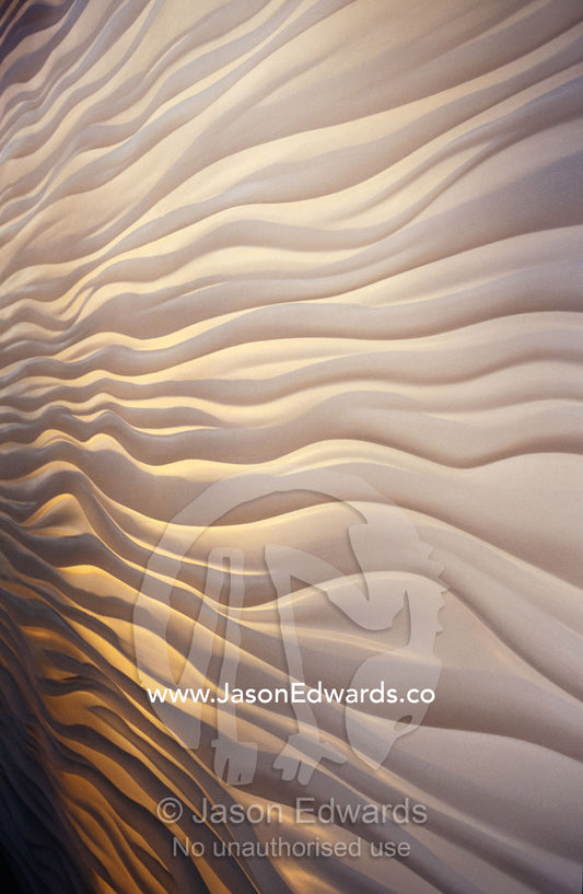 Lighting illiuminates an architectural display of waves in a wall. Carlton Gardens, Victoria, Australia.