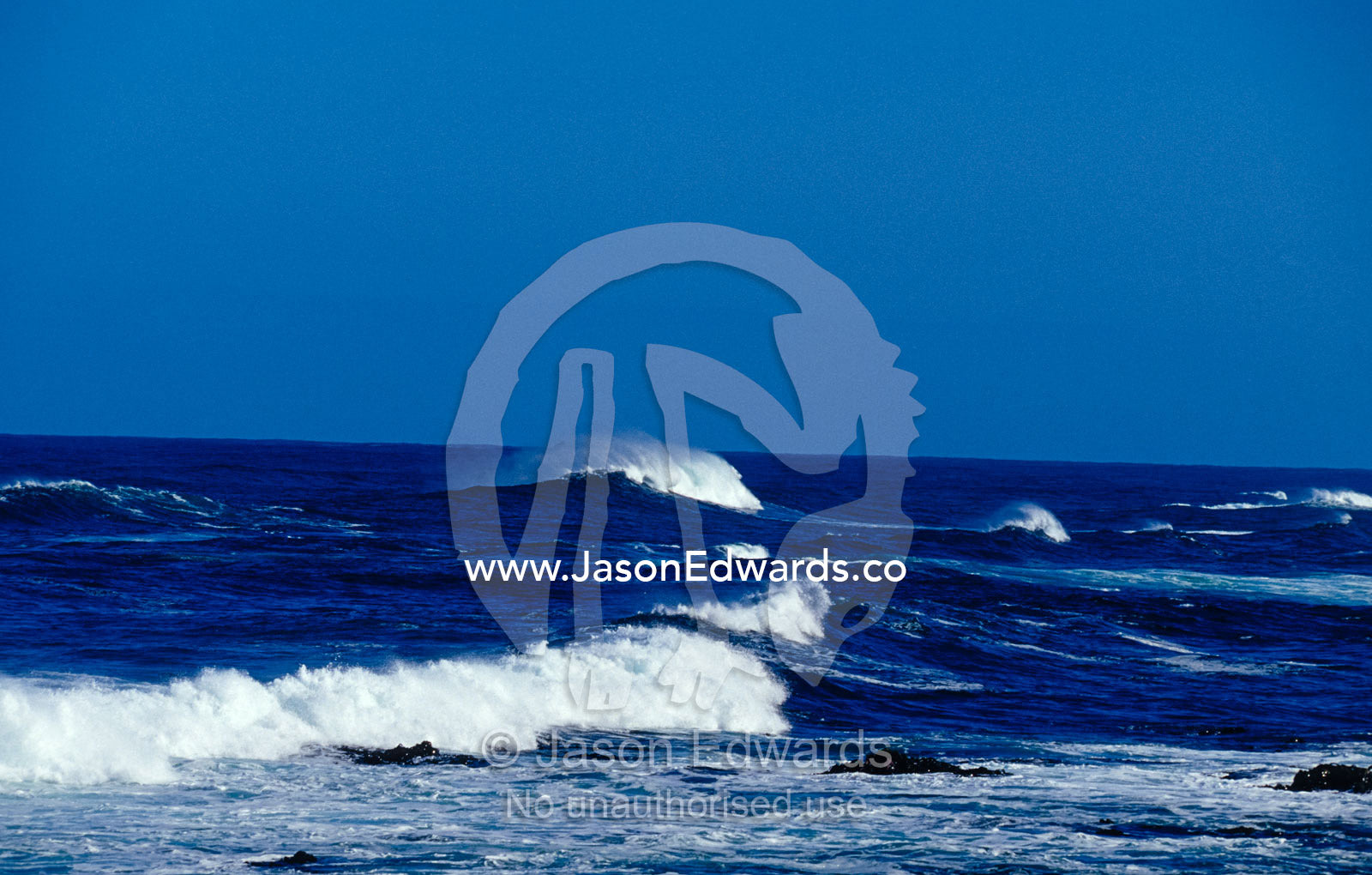 A large swell produces huge waves that  smash into a rugged coastline. South West Conservation Area Tasmania, Australia.