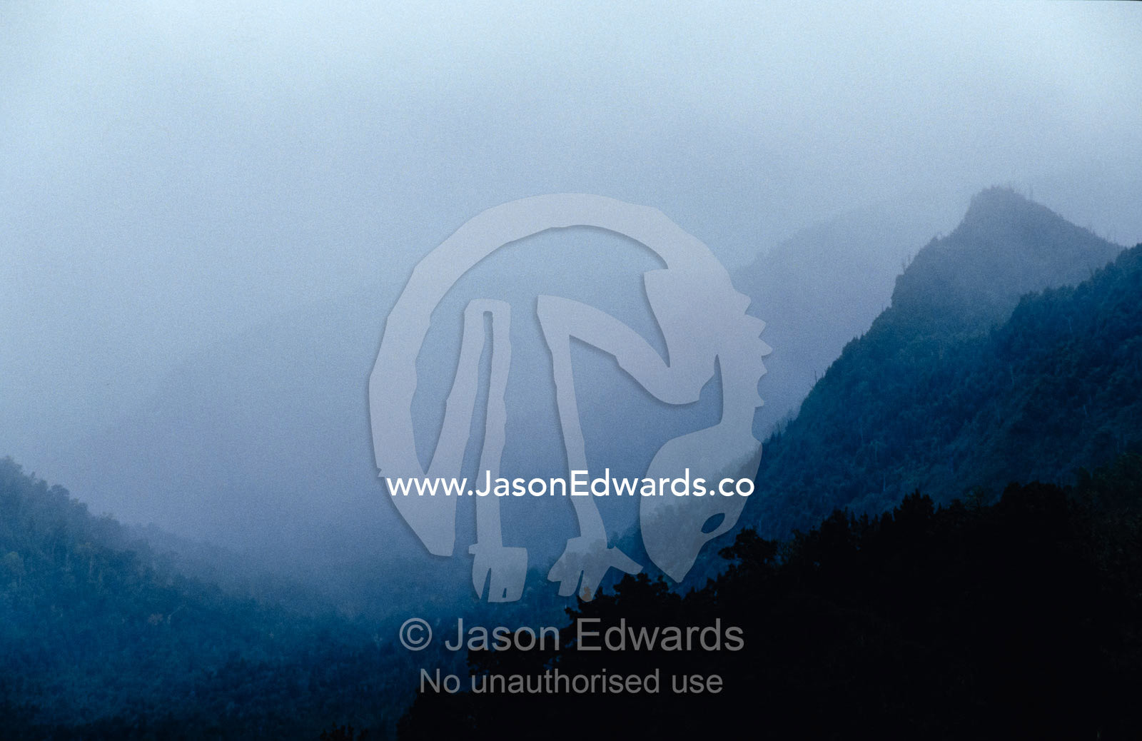 Mist and rain clouds fill a rugged and remote forested mountain valley Surprise Valley, King William Range and Loddon Range, Tasmania, Australia.