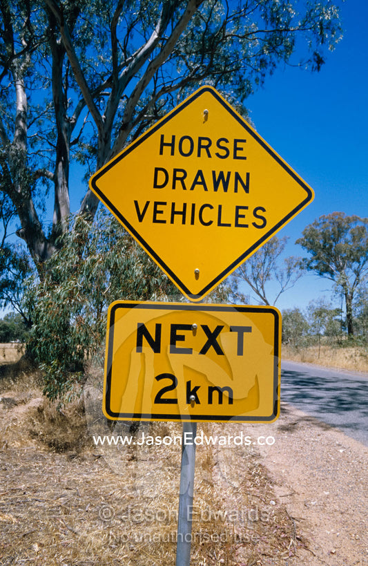 Bright yellow roadside graphics warn of horse-drawn traffic. near Rheola, Central Victoria, Australia.