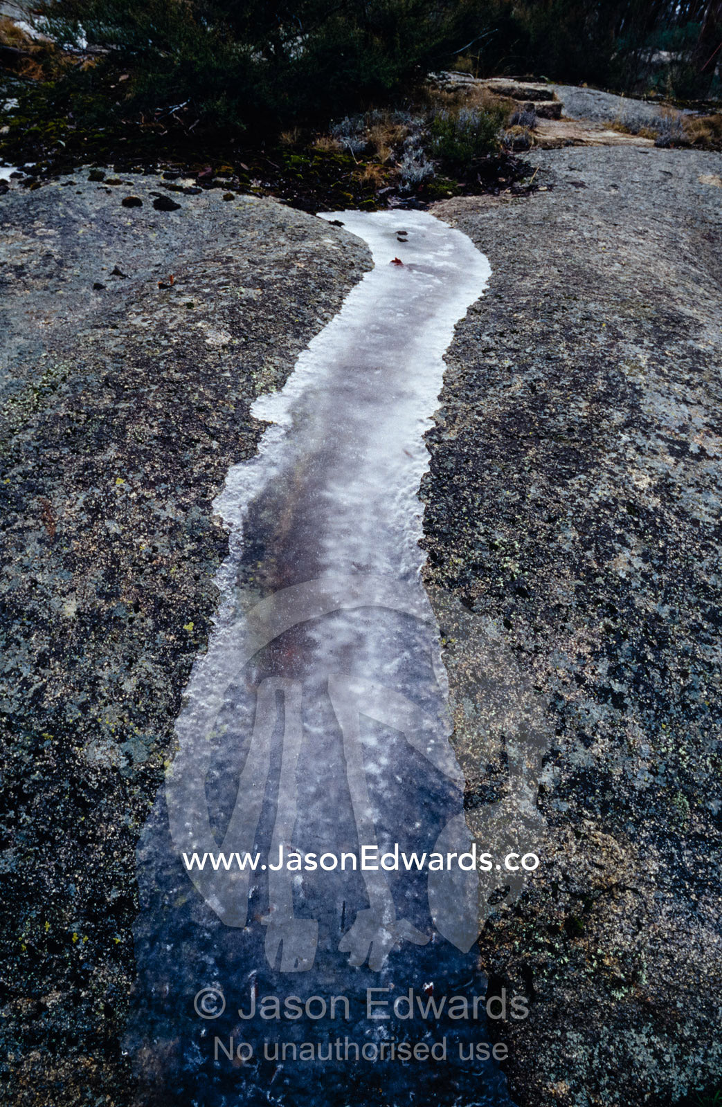 A small stream frozen solid whilst flowing over a granite boulder. Mount Buffalo National Park,Victoria, Australia