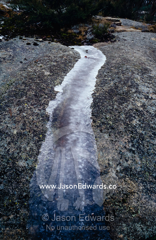 A small stream frozen solid whilst flowing over a granite boulder. Mount Buffalo National Park,Victoria, Australia