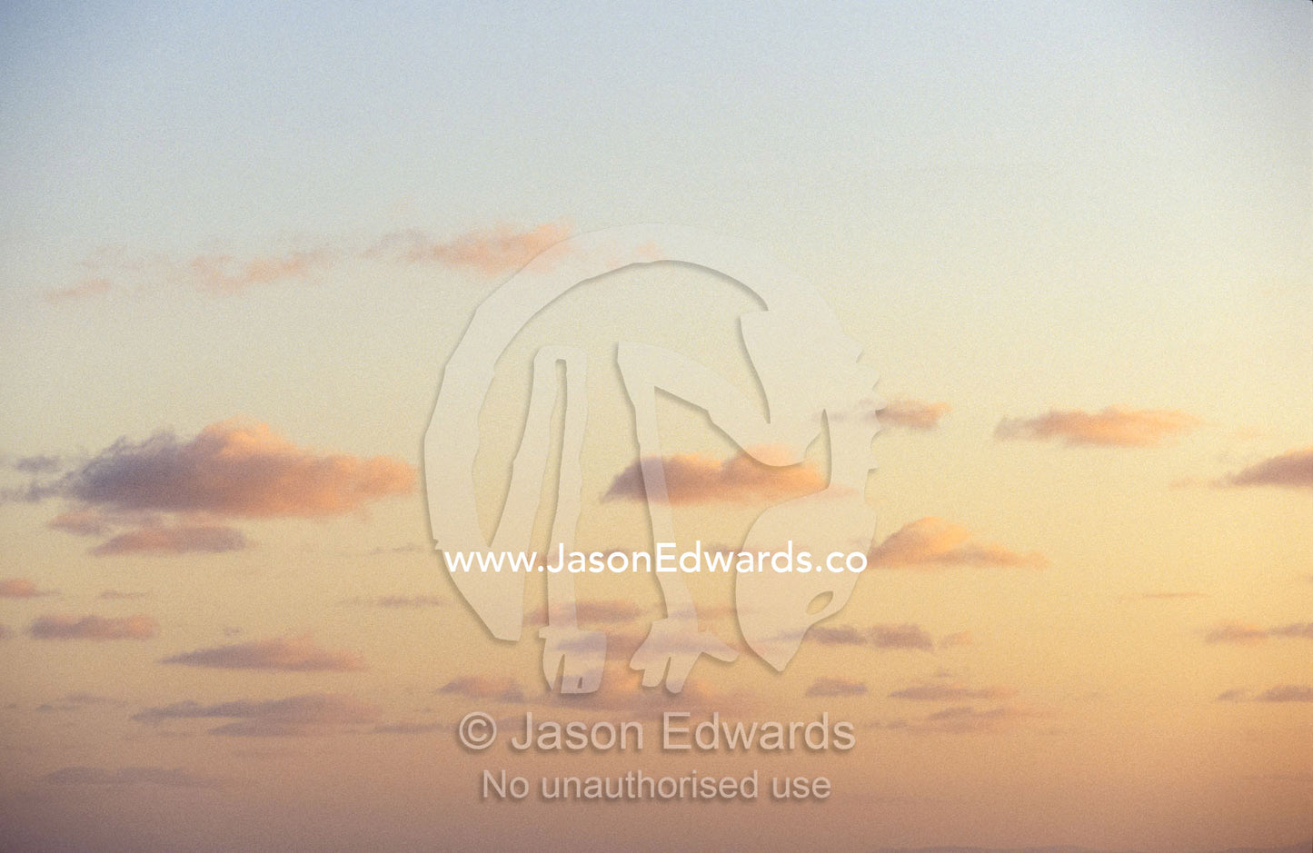 Light, fluffy pastel sunset storm clouds float over a tropical ocean. Coral Sea Island Territory, Australia.