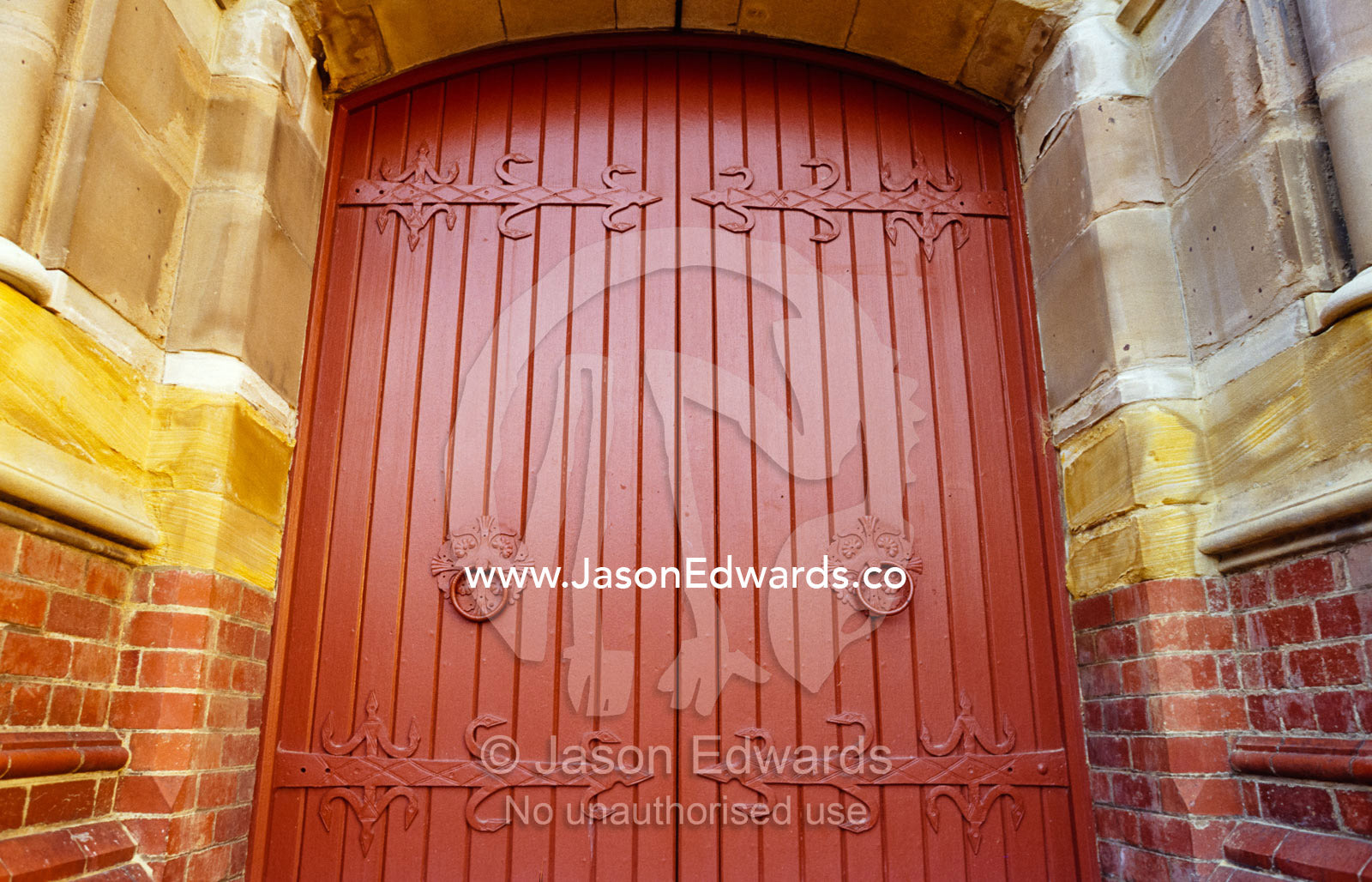 A Christian church facade with ornate brick work and heavy doors. Launceston, Tasmania, Australia.