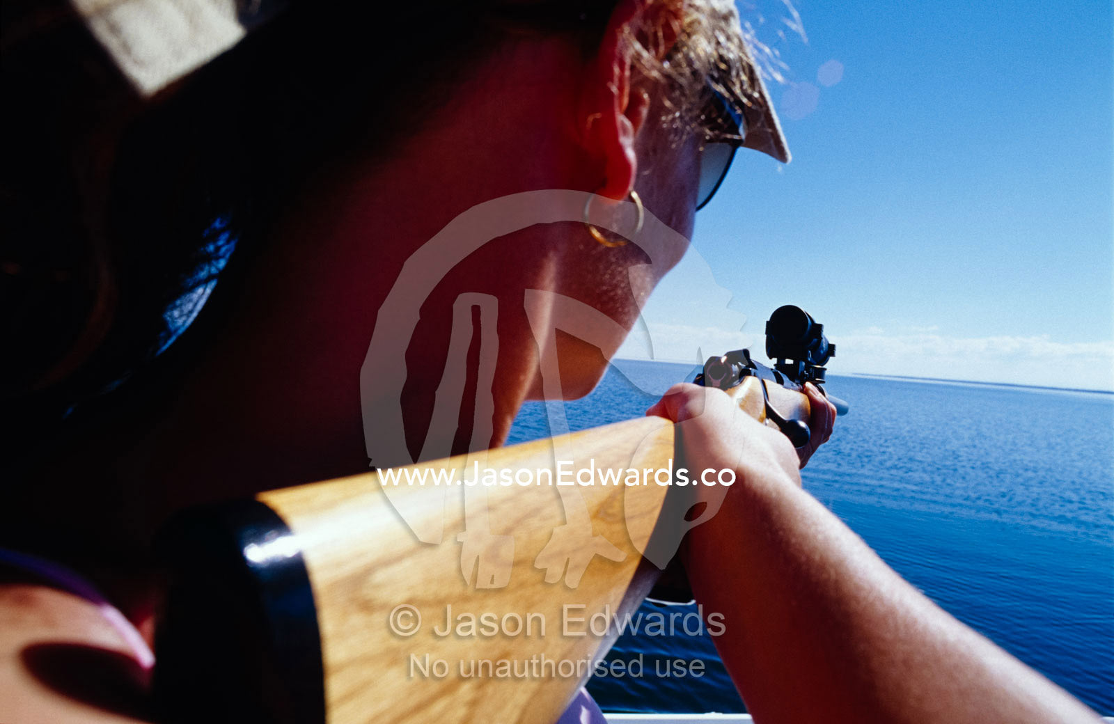 A Phd candidate collecting DNA samples from dolphins using a dart gun. The Lakes National Park, Victoria, Australia.