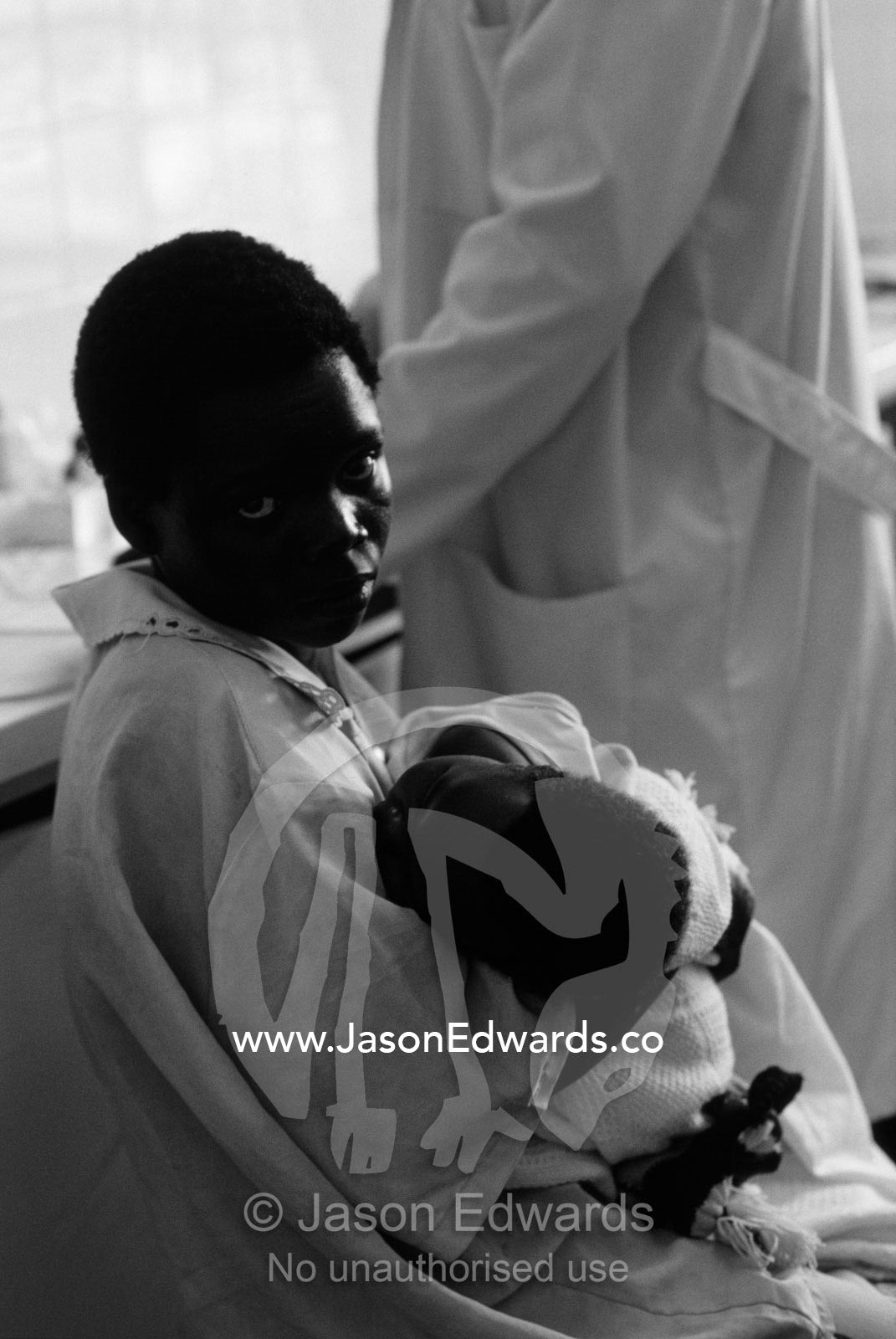 A teenage African mother awaits a HIV AIDS blood test in a hospital. Tororo District Hospital, Uganda.