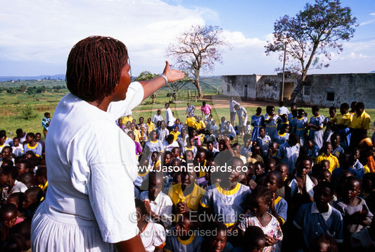 African school children in uniform get in formation for their teacher. Tororo Prison School, Tororo District, Uganda.