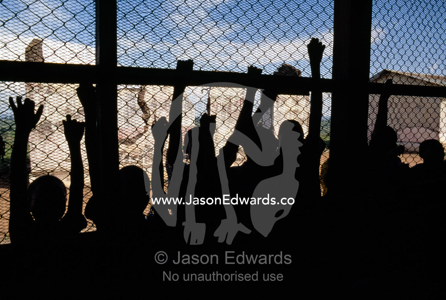 Children cling to the wire of a classroom to listen to school lessons. Tororo Prison School, Tororo District, Uganda.