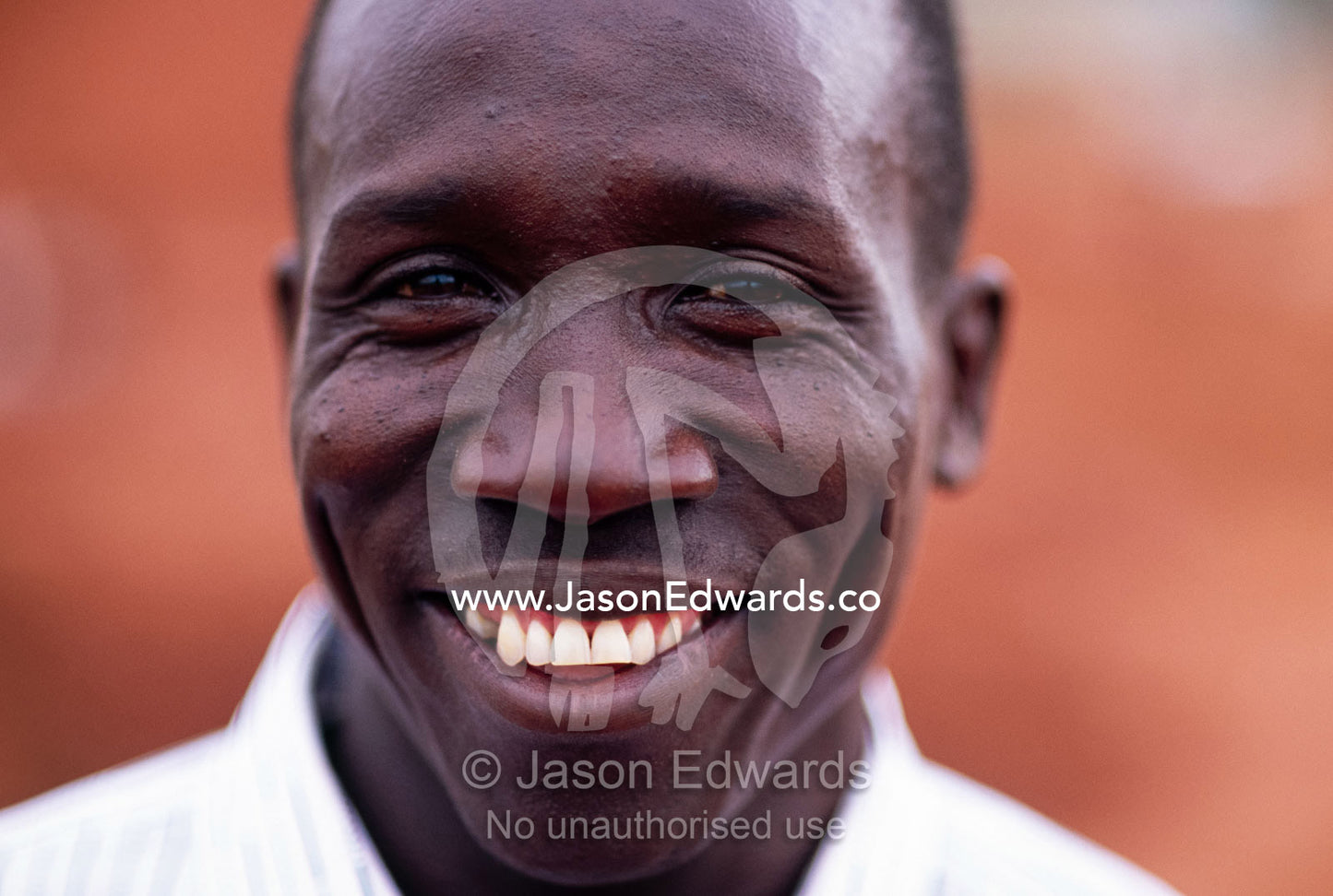The beaming smile of a handsome Ugandan man with laughing eyes. Lake Victoria, Kampala, Uganda.
