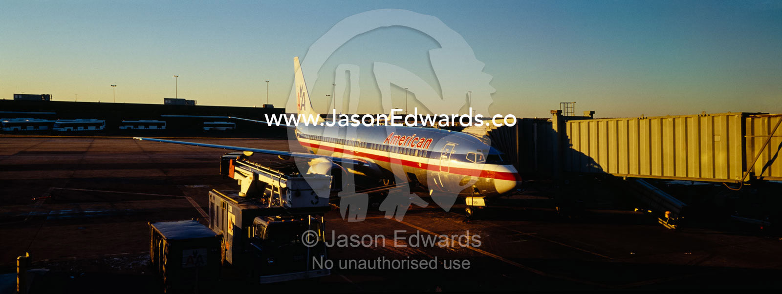 An aircraft waiting to collect passengers from a terminal at dawn. Dulles Airport, Washington DC, Untied States of America, USA.