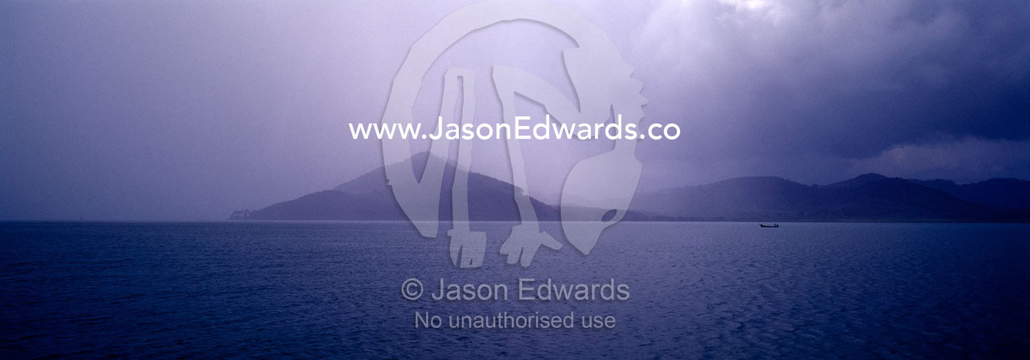 Storm clouds and torrential rain shroud distant tropical islands. Phang Nga Bay Marine National Park, Thailand.
