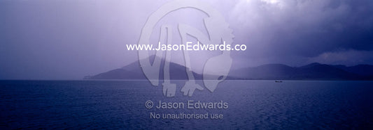 Storm clouds and torrential rain shroud distant tropical islands. Phang Nga Bay Marine National Park, Thailand.