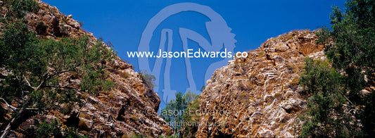 Ancient red desert cliffs come together at the entrance to a gorge. Limmen National Park, Northern Territory, Australia.