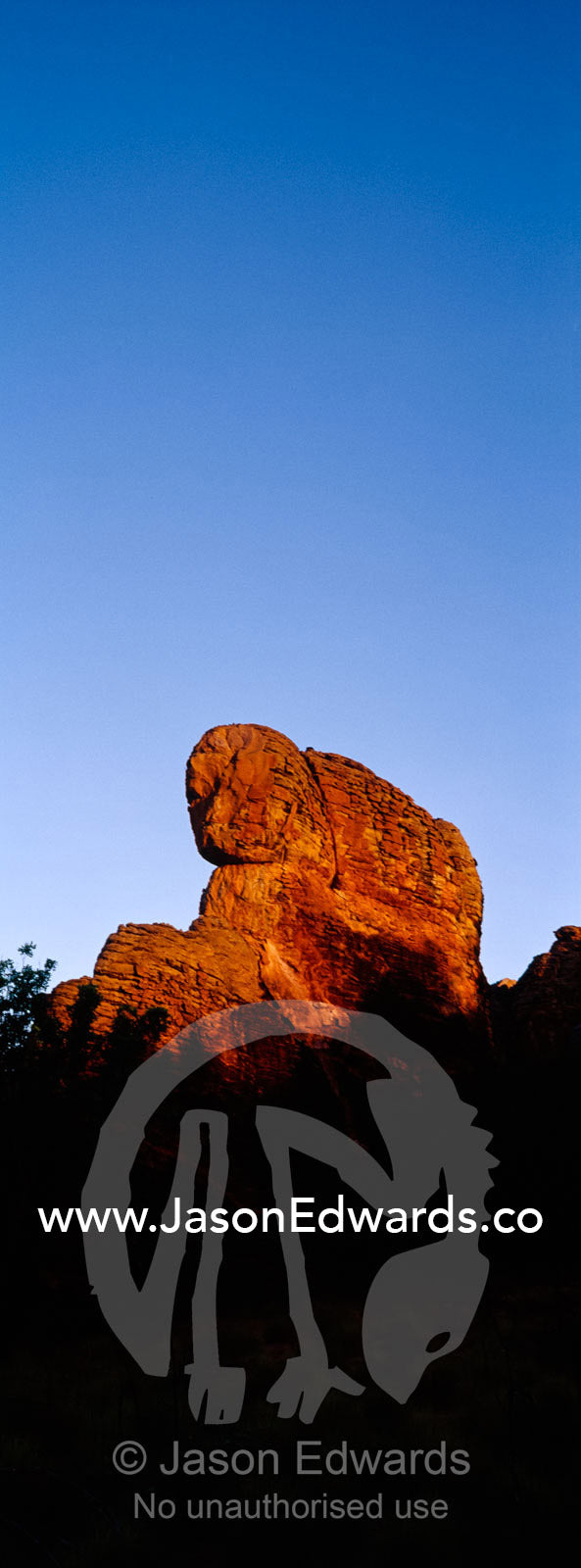 Ancient red rock formations rise above the desert plain at sunset. Limmen National Park, Northern Territory, Australia.