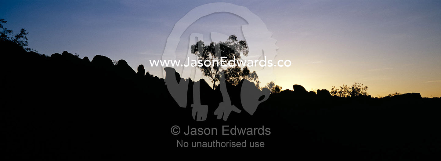 Silhouettes of ancient red rock formations rise above the desert plain Limmen National Park, Northern Territory, Australia.