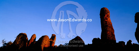 Ancient red rock formations rise above the desert plain at sunset. Limmen National Park, Northern Territory, Australia.