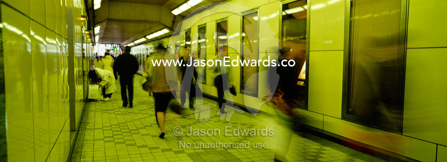 Commuters race between railway platforms to catch trains in the subway Shinjuko Station, Tokyo, Japan.