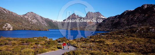 Hikers walking the Dove Lake trail beneath Cradle Mountain in Fall. Cradle Mountain Lake St Clair National Park, Tasmania, Australia.