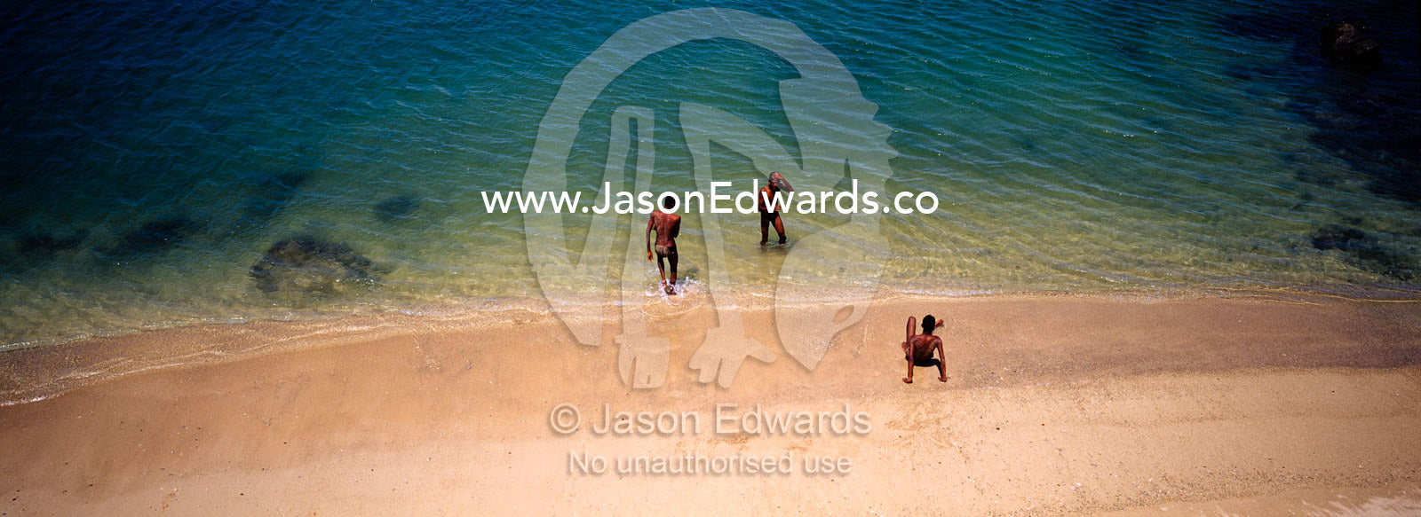 An aerial view of teenage boys playing on the beach by turquoise seas. Galle, Sri Lanka.