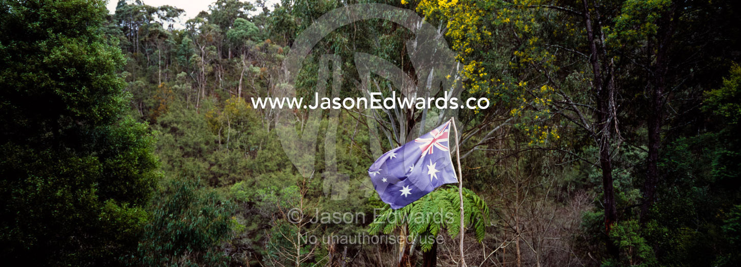 An Australian flag flaps in the breeze in the High Country forest. Jamieson, Victoria, Australia.