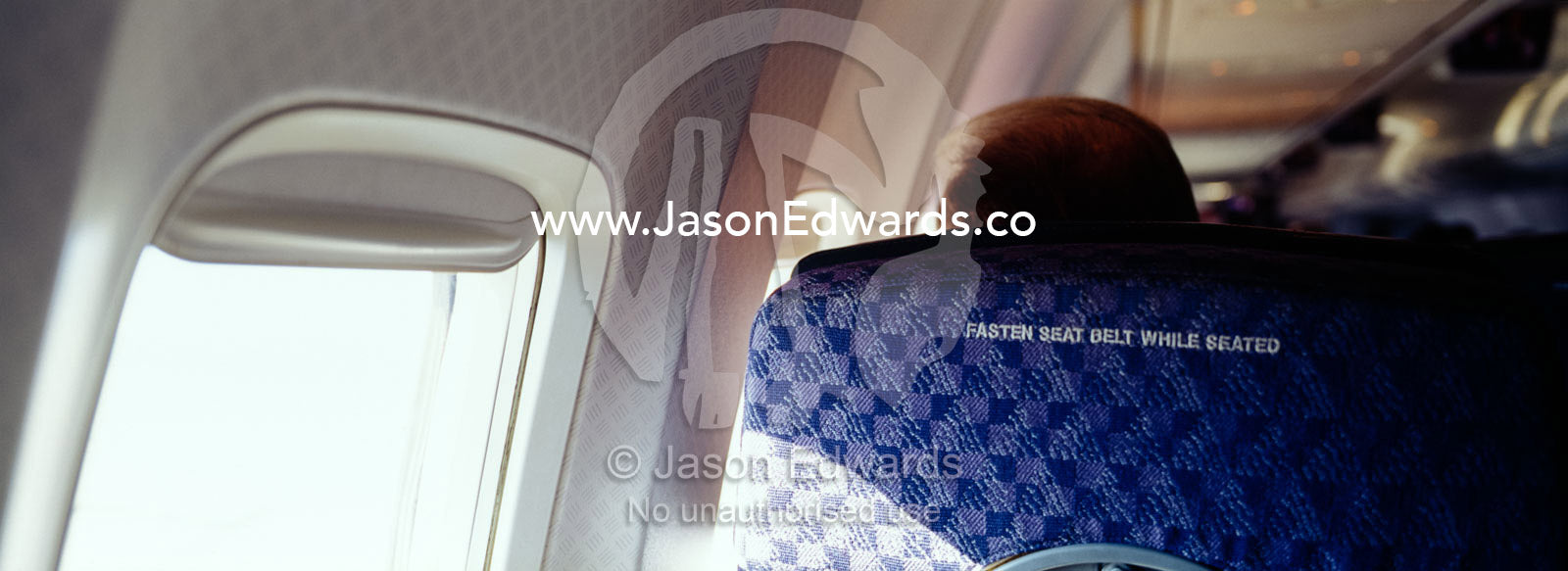 A passenger on a commercial aircraft and the fasten seat belts sign. Over United States of America.