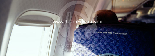 A passenger on a commercial aircraft and the fasten seat belts sign. Over United States of America.