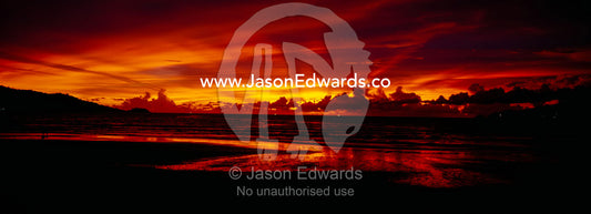 A flaming sunset erupts over Patong's famous beach and promenade. Patong Beach, Phuket, Thailand.