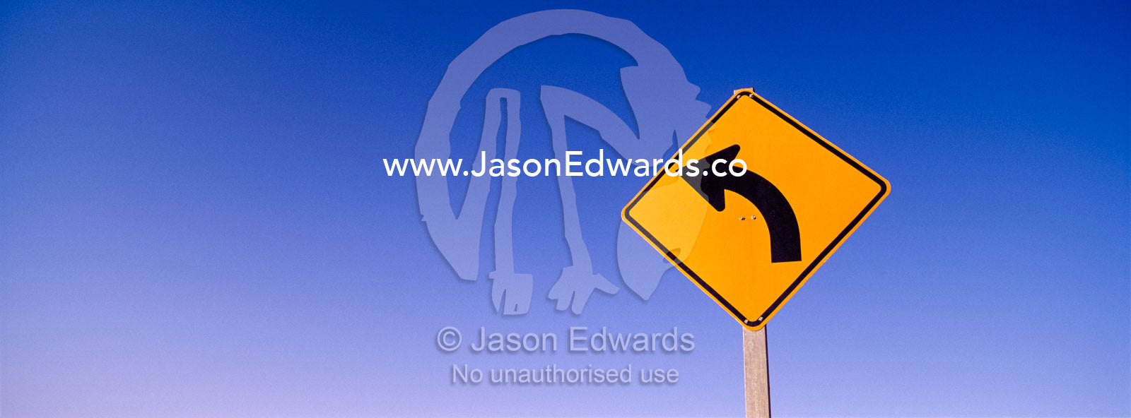 A sign warns of a rare bend in the road. near Broken Hill, New South Wales, Australia.