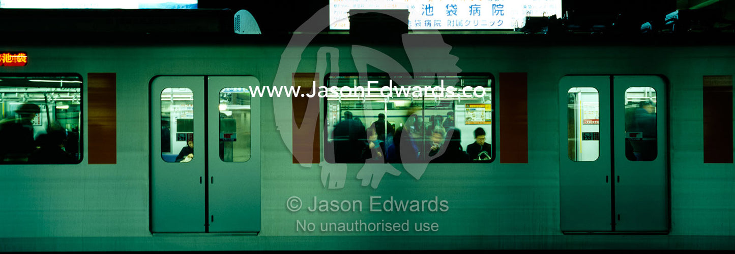 Crowds of commuters cram into a train carriage at Ikebukuro Station. Ikebukuro Station, Tokyo, Japan.