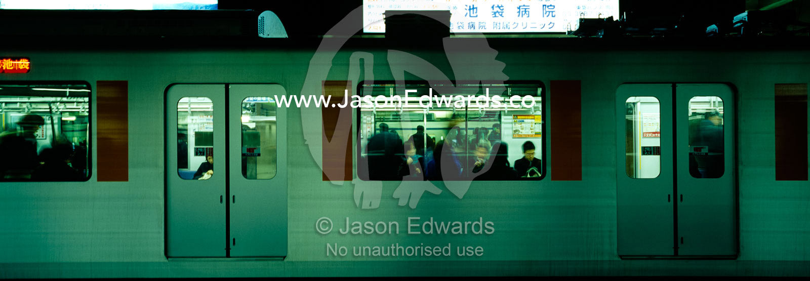 Crowds of commuters cram into a train carriage at Ikebukuro Station. Ikebukuro Station, Tokyo, Japan.