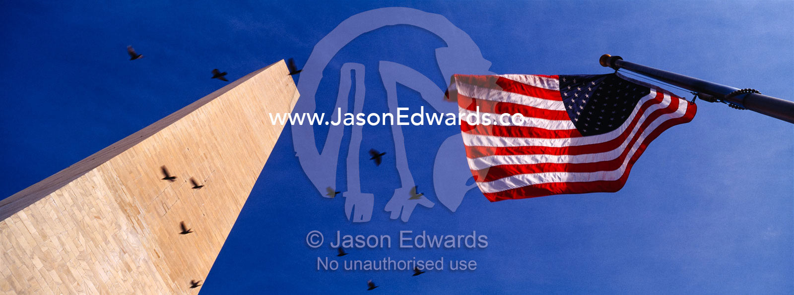 An American flag flies proudly next to the Washington Monument. Washington DC, USA, United States of America.